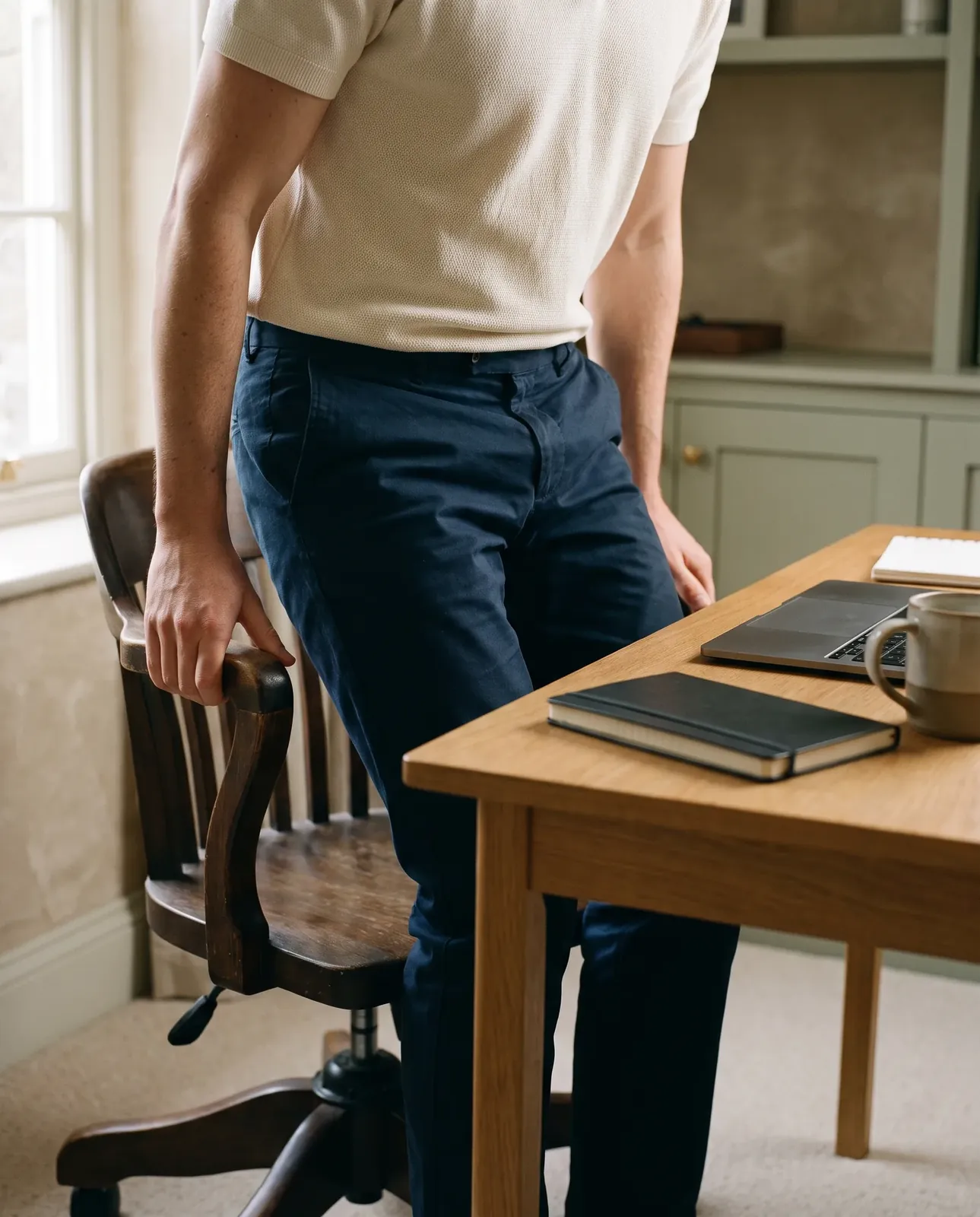 Standing up from a wooden desk chair in a home office