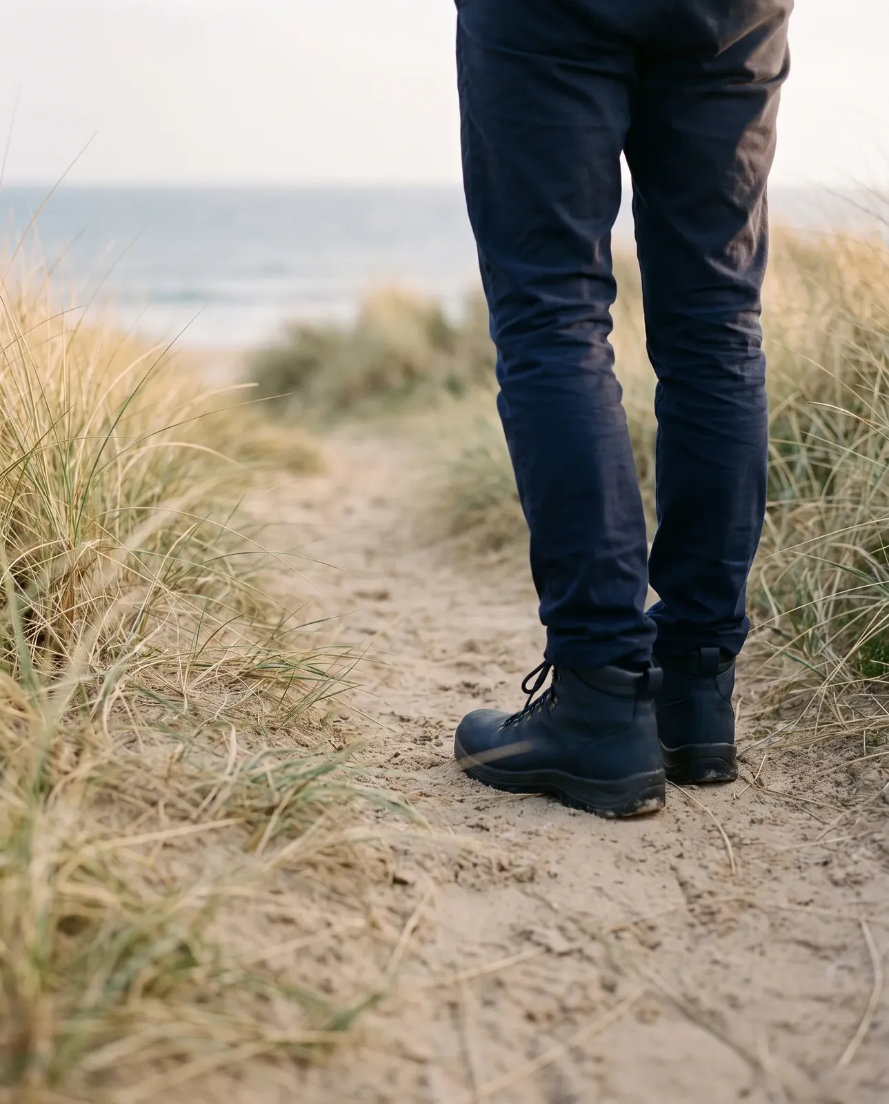 Walking boots on a sandy coastal footpath through the dunes