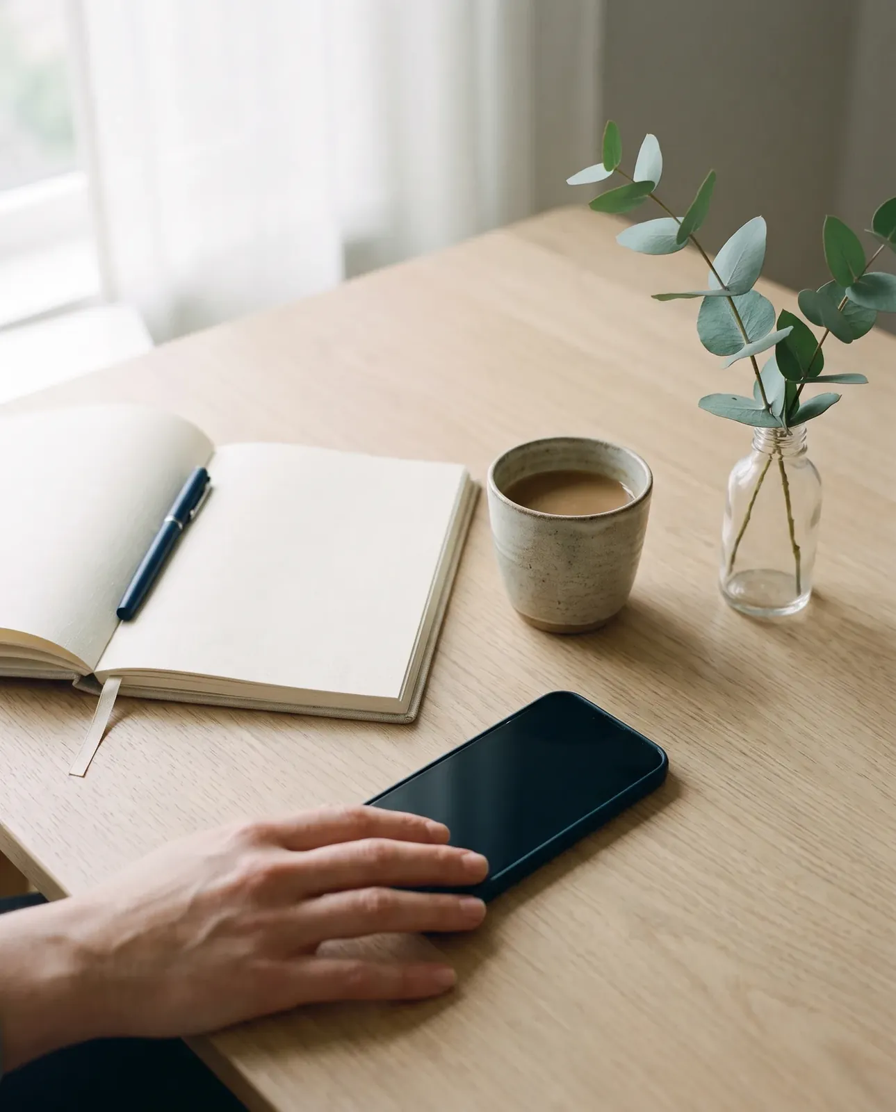 A phone and notebook on a kitchen table