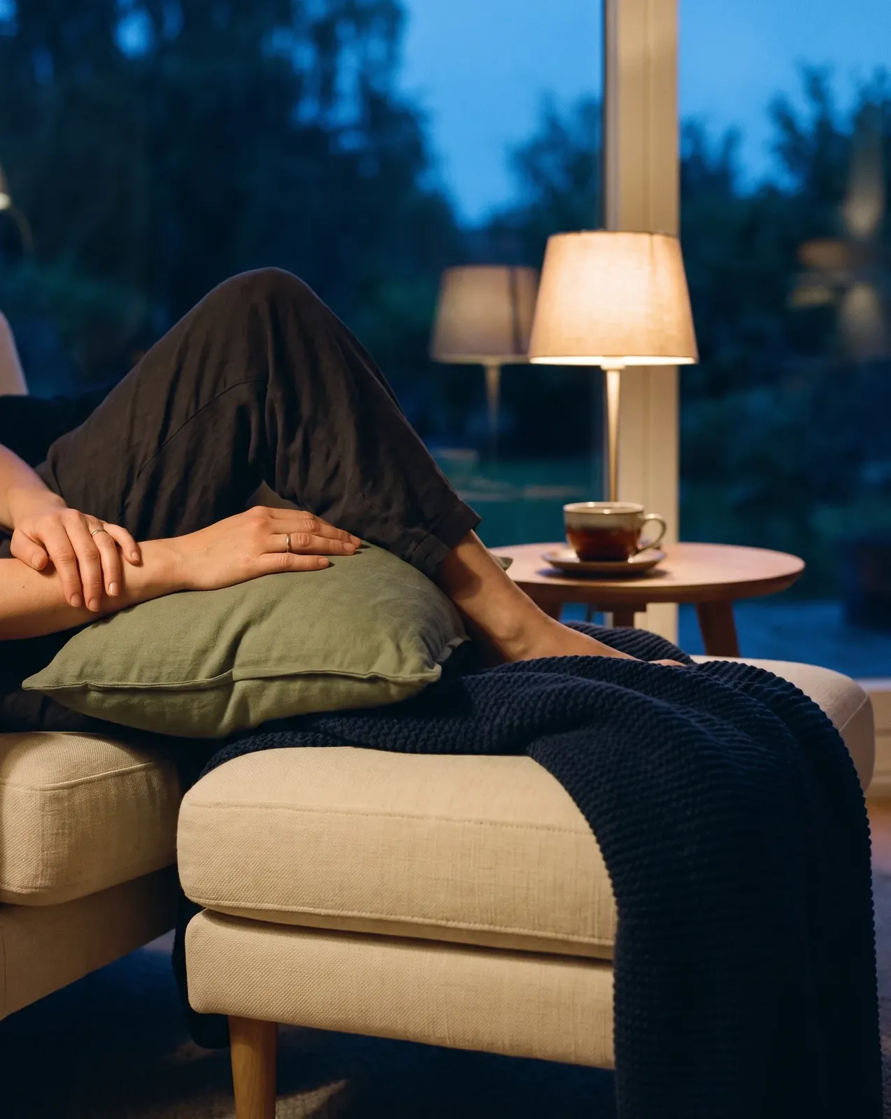 Resting a leg on a footstool by lamplight in the evening