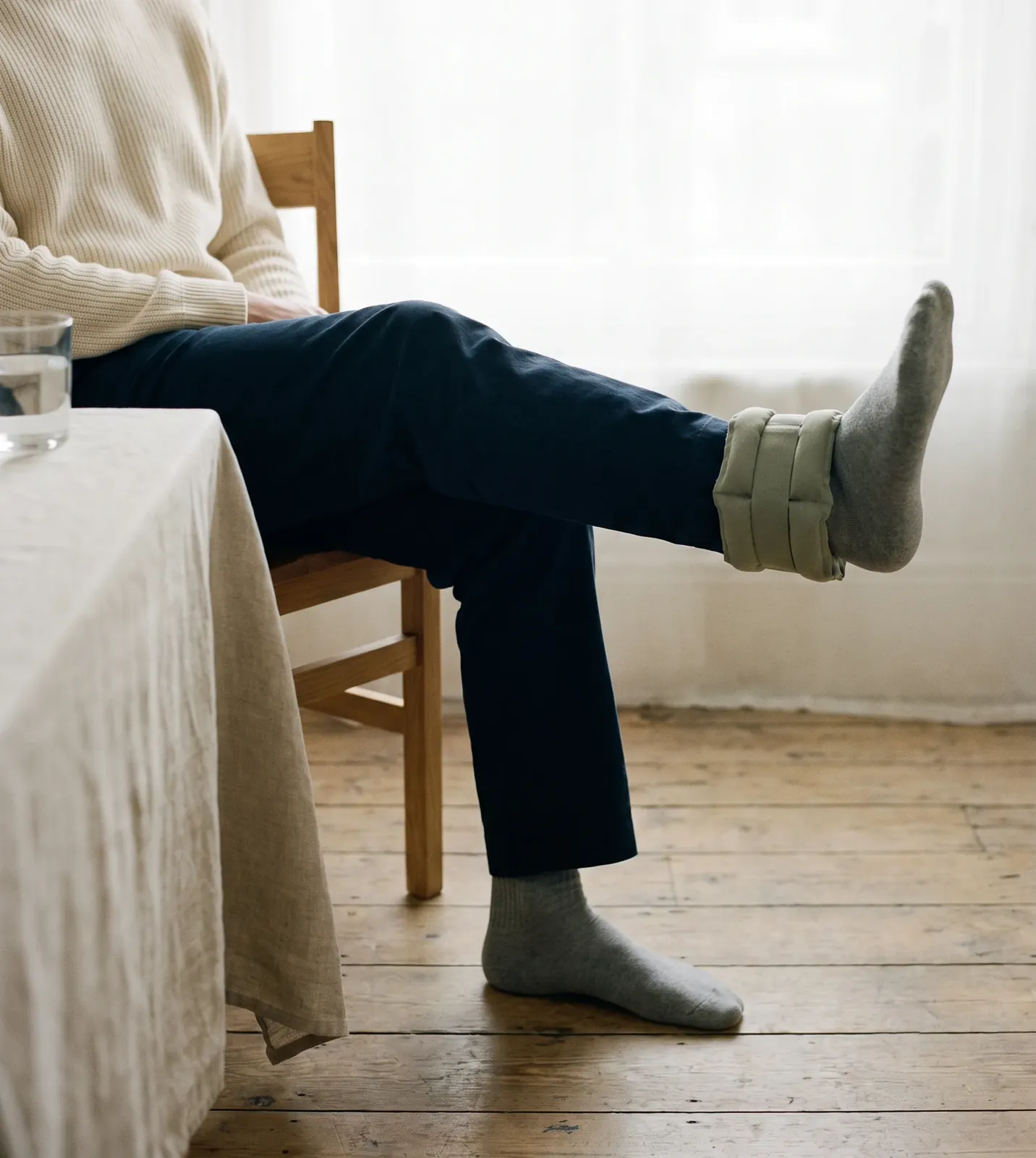 Seated knee extension with a soft ankle weight, strengthening the thigh muscles at home